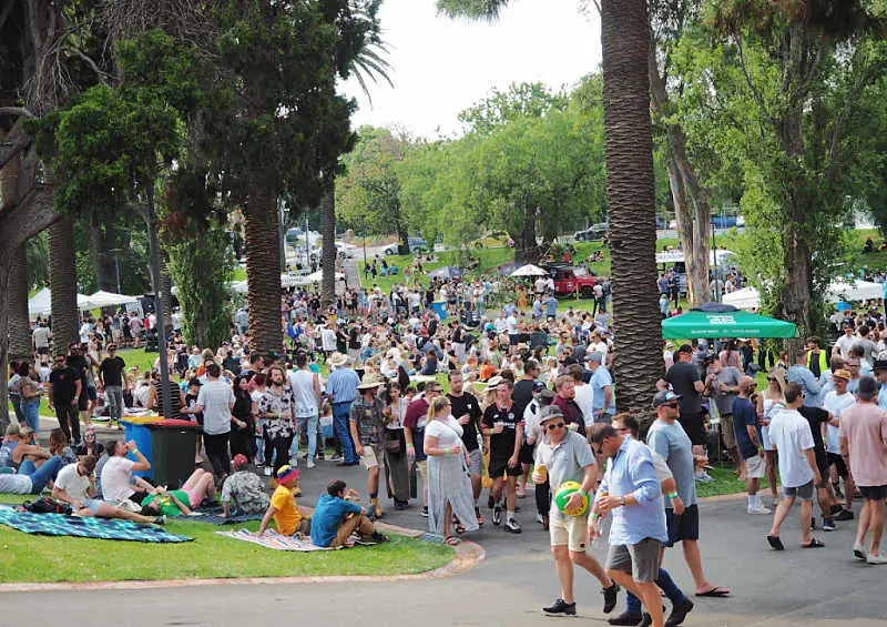 People sitting and walking amongst the trees at The Great Australian Beer Festival.