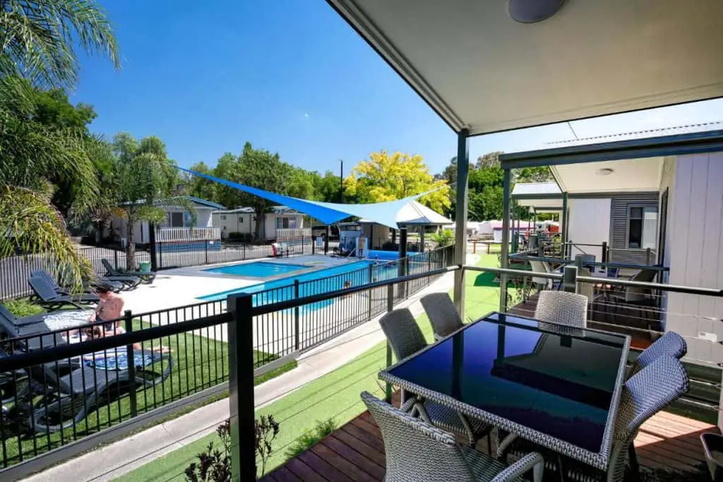 Outdoor dining area overlooking the pool at a caravan park in Geelong.