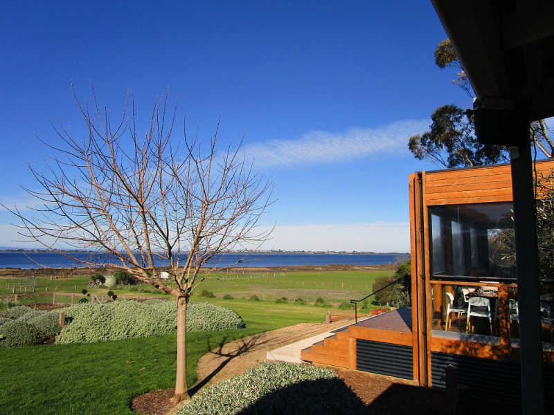 View of Basils Farm restaurant in Queenscliff with panoramic water views and blue skies.