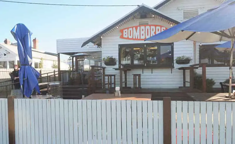 Front garden at Bomboras Torquay restaurant with umbrellas and front fence.