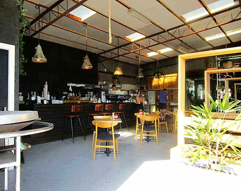 Box Office Cafe in Pakington Street entrance with tables and chairs and greenery.