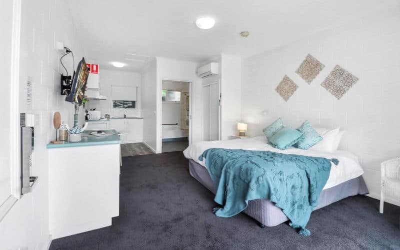 Guest room with a bed and rug at Geelong CBD Accommodation.