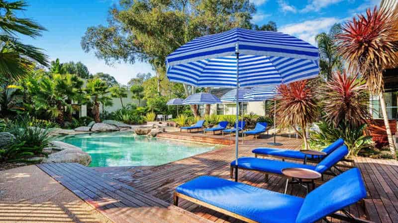 Relaxing pool area with sun lounges and umbrellas at Eden Oak Geelong accomodation.