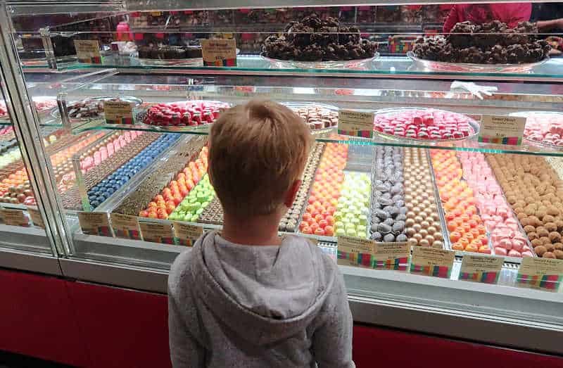 Young boy looking at chocolates in a display case at the Great Ocean Road Chocolaterie in Anglesea Australia.
