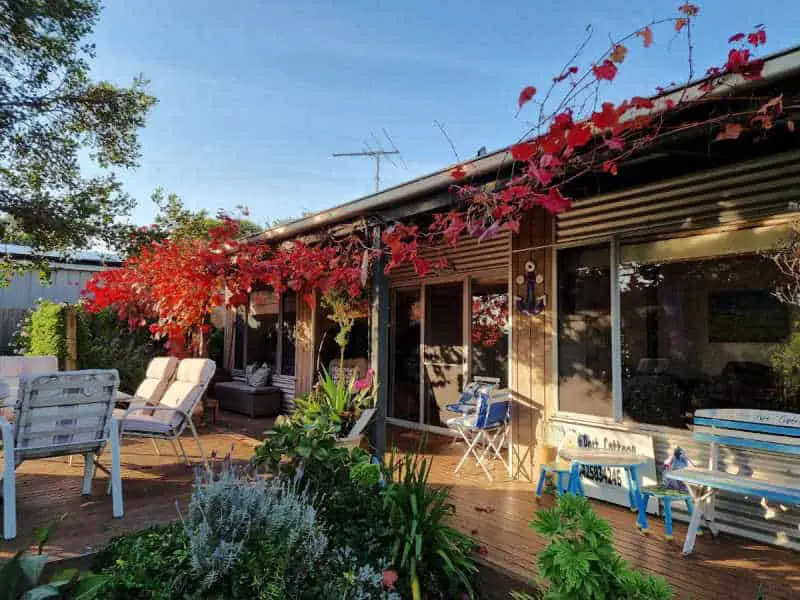 Front entrance to Little Port Cottage with garden and chairs.