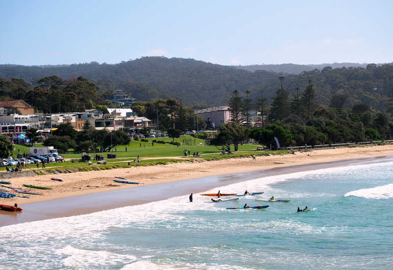 View of Lorne Beach with grassy foreshore and kayaks one of the many fun Lorne things to do.