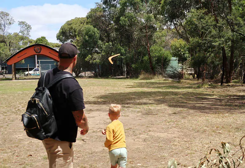 Man with a small boy throwing a boomerang