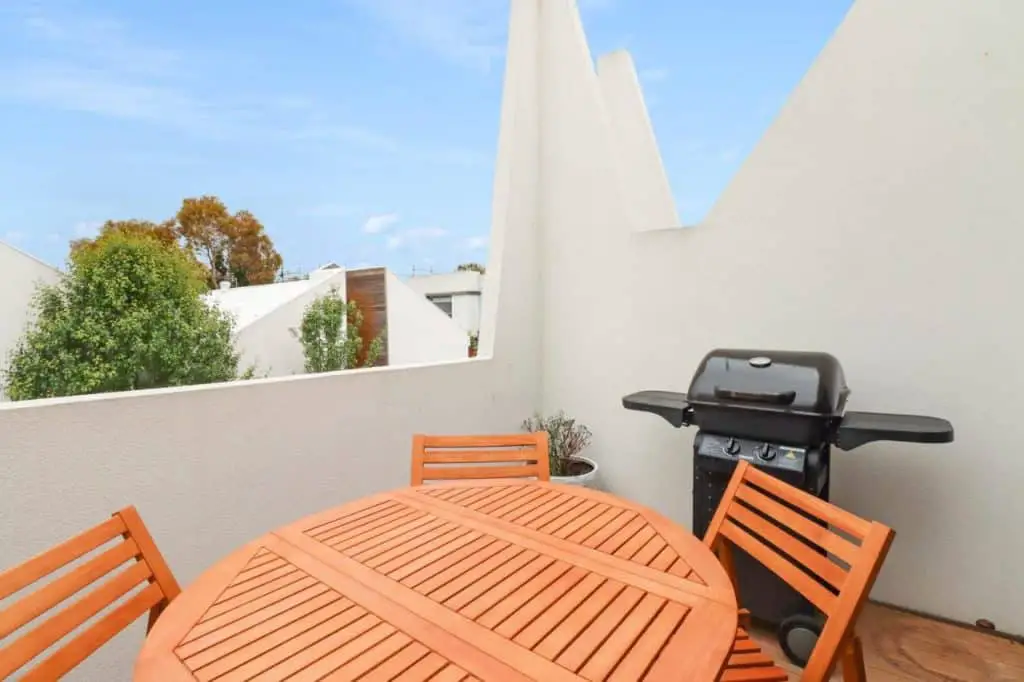 Balcony courtyard with table and chairs and a barbecue at Percy Escape dog friendly Geelong accommodation.