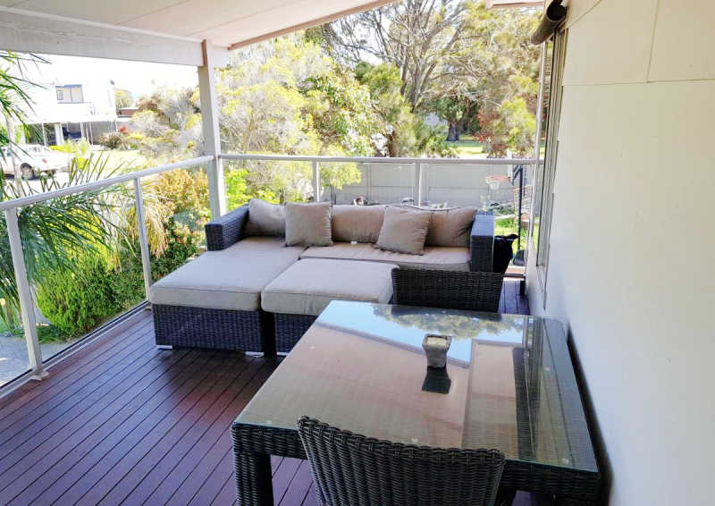 Decking area with outdoor seating at the Portarlington Beach Shack accommodation.