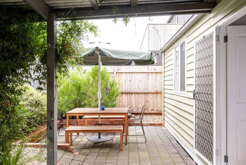 Courtyard with outdoor furniture and umbrella at Quartz Cottage a popular place to stay in Geelong.