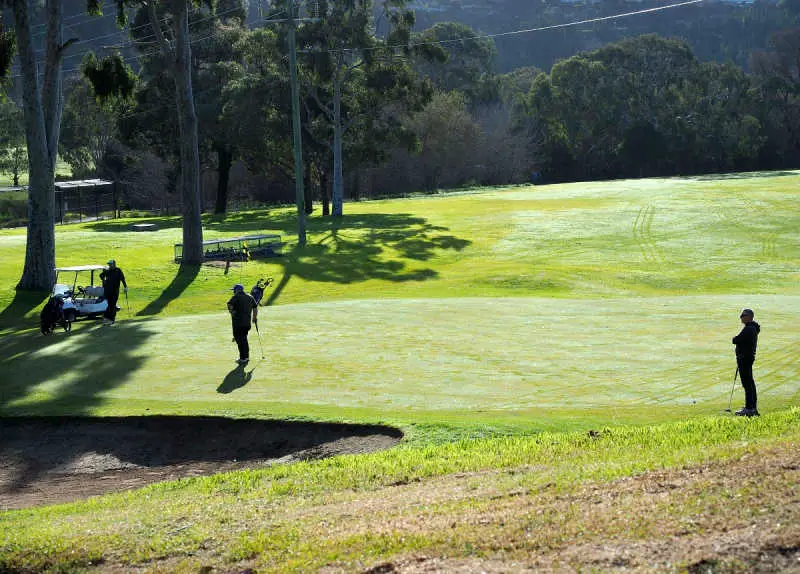 Golfers and buggy on a Queens Park fairway