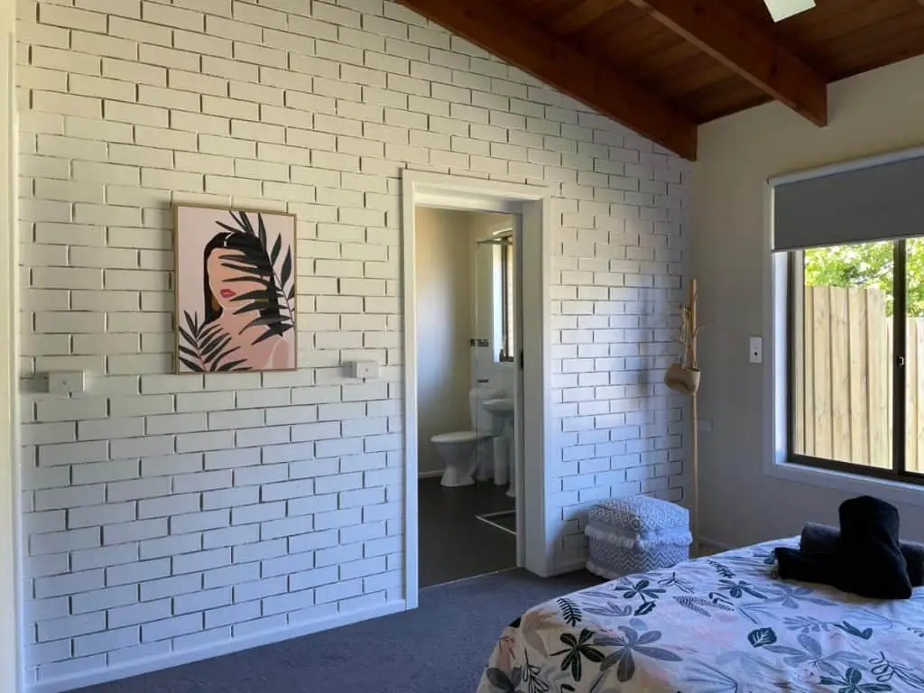 Bedroom with feature wall and artwork at Moolap Retreat a dog friendly place to stay in Geelong.