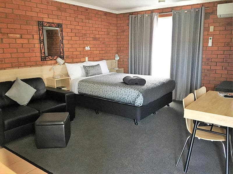 Guest room with bed, couch, and desk at Shannon Motor Inn Geelong.