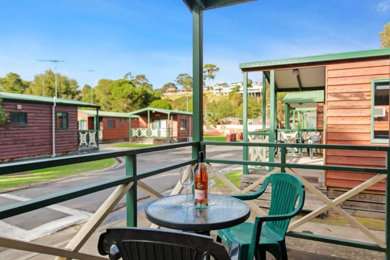 Outdoor seating with with a wine bottle at one of the best Geelong Caravan Parks.