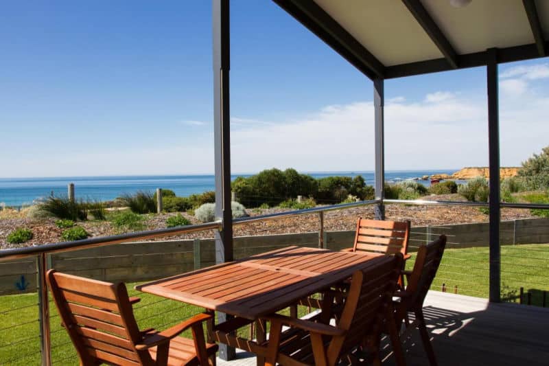 Deck with outdoor setting and ocean views at a Torquay Foreshore Caravan Park cabin.