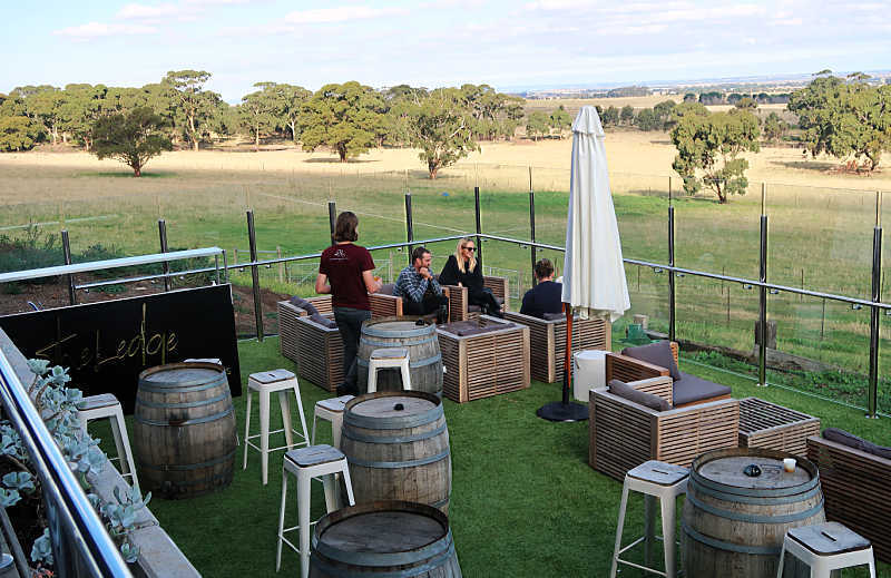 Picture of people relaxing with wine with views of the Victorian countryside in the background. 